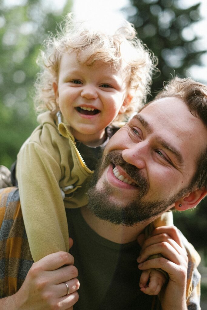 Un père qui essaye des aides auditives et qui joue avec son enfant
